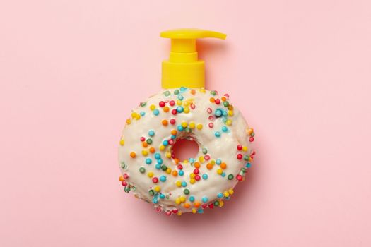 Tasty donut with dispenser on pink background