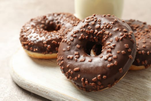 Milk and tasty donuts on gray table, close up