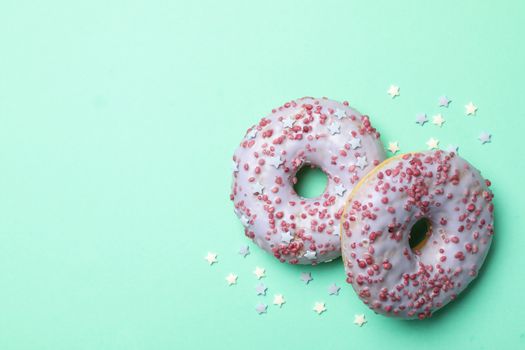 Tasty donuts on mint background, space for text