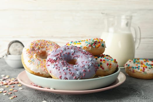 Concept of tasty food with donuts and milk on gray background