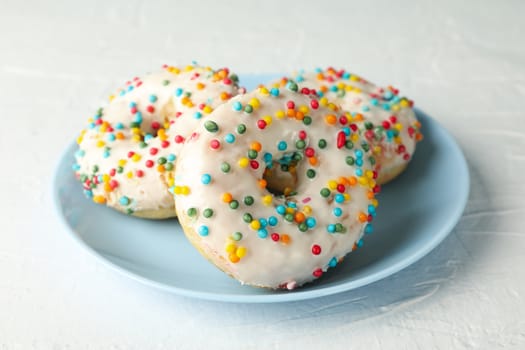 Plate with tasty donuts on white background