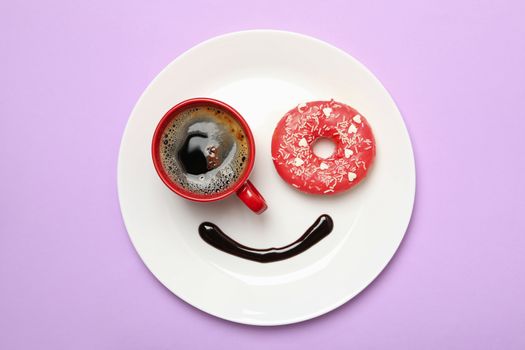 Smile face made of plate with donut, chocolate sauce and coffee on violet background