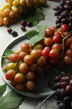 Composition with grape and towel on gray background