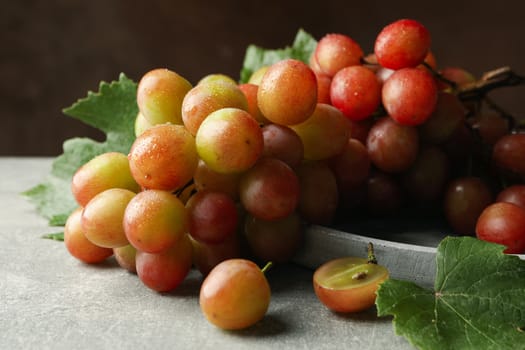 Tray of grape on gray table against brown background