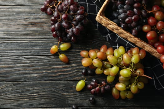 Basket with ripe grape on wooden background