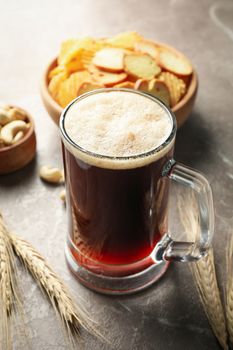 Beer, wheat and snacks on gray background, close up