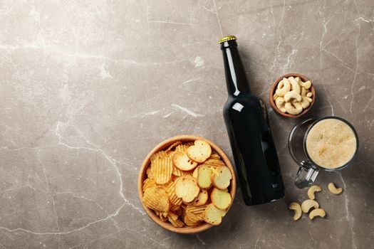 Beer and snacks on gray background, top view