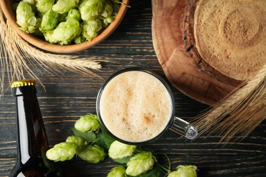 Beer, hop and wheat on wooden table