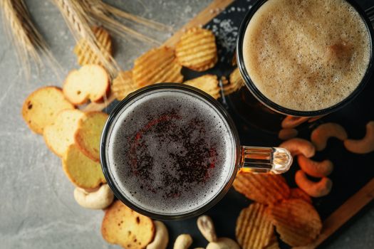 Beer, wheat and snacks on gray table