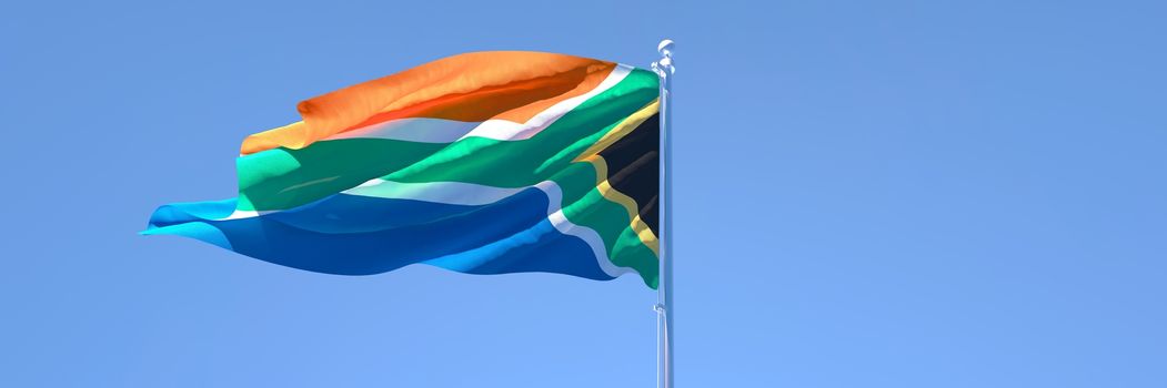 3D rendering of the national flag of South Africa waving in the wind against a blue sky
