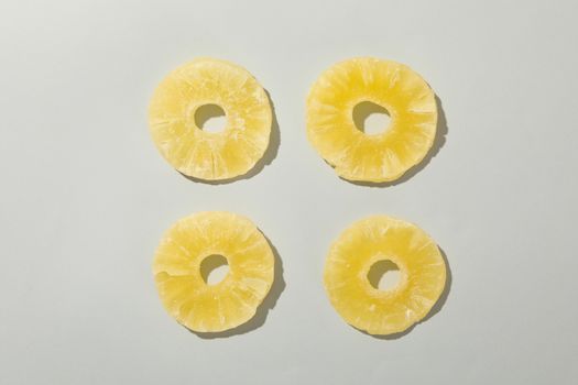 Dried pineapple slices on white background, top view