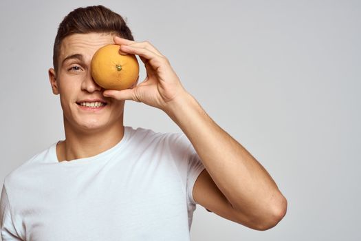 A man with an orange and a white t-shirt on a light background cropped view of the model. High quality photo