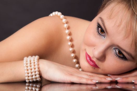 the face of a young attractive woman with pearl necklace