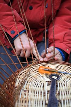 Hands of a craftsman working on a wicker basket