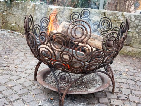 Outdoor fire place in an iron basket