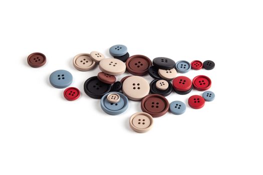 Pile of color brown, beige, grey, red, black plastic matte buttons on white, beautiful needlework, minimalism. Use for sewing. Space for text.