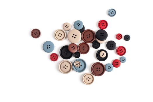 Pile of color brown, beige, grey, red, black plastic matte buttons on white, beautiful needlework, minimalism. Use for sewing. Space for text.