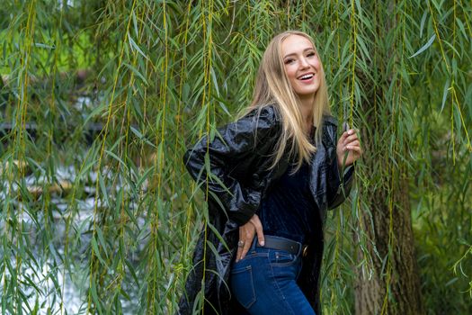 A gorgeous blonde model poses outdoors in her fall clothes