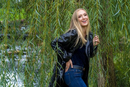 A gorgeous blonde model poses outdoors in her fall clothes