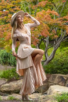 A gorgeous blonde model poses outdoors in her fall clothes