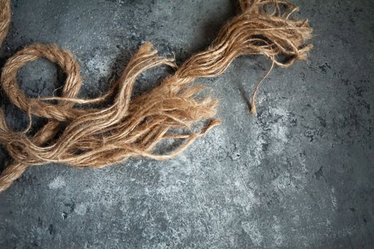 large battered jute rope on a gray abstract concrete background. Space for text.