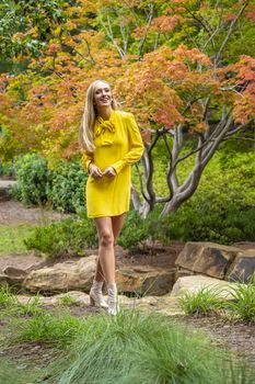 A gorgeous blonde model poses outdoors in her fall clothes