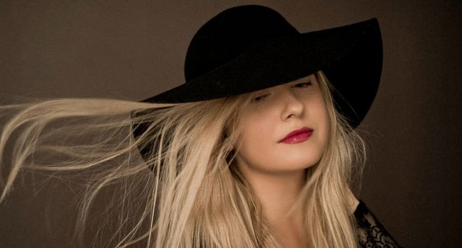 Classy blonde woman wearing a hat, artistic film portrait for fashion campaign and beauty brand design