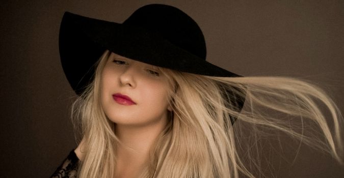 Classy blonde woman wearing a hat, artistic film portrait for fashion campaign and beauty brand design