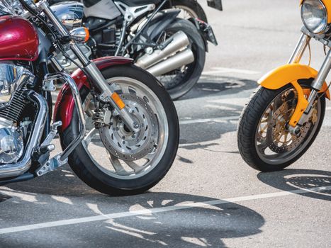 Motorcycles with shiny chrome parts are parked in the parking lot. Quite dangerous, but fast vehicle for moving around the city.