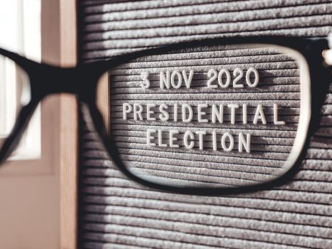 Announcement of USA Presidential Election at 3rd November 2020. Call to go to the vote. Closer view on letter board through eyeglasses.