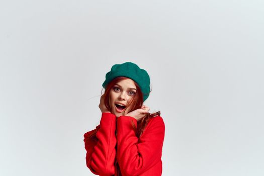 Woman in red coat and in green hat on isolated background cropped model with Copy Space emotions. High quality photo