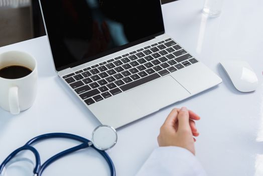 Medicine doctor's working on desk. Closeup of Stethoscope. Hand of Asian woman physician explain to patients on table front laptop computer at the hospital office, Healthcare medic concept