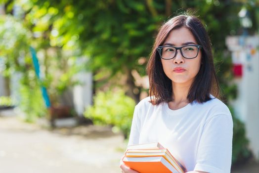 Portrait of Asian teen beautiful young woman wear eyeglasses smile have dental braces on teeth laughing at outdoor she hold education books on hand, Medicine and dentistry concept