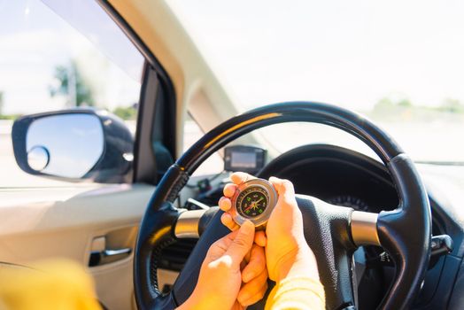 Asian woman inside a car and using compass to navigate while driving the car she find navigation location to go, Transportation and vehicle concept