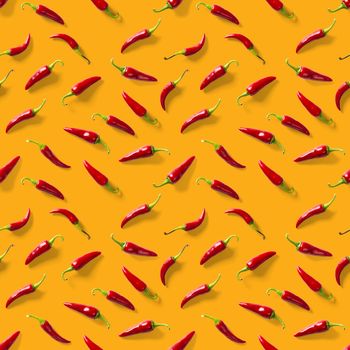 Red hot chilli seamless peppers pattern. Seamless pattern made of red chili or chilli on orange background. Minimal food pattern. Food background.