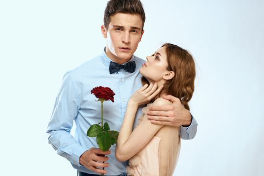 Man and woman with a red rose on a light background love family hugs. High quality photo