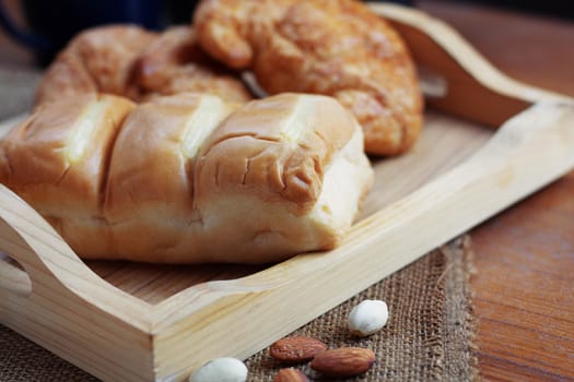 Bread in a tray placed on wooden table.