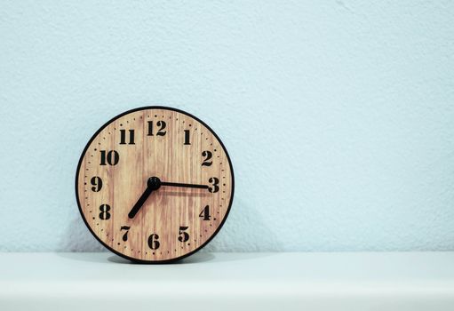 Classic alarm clock on wooden at the wall.
