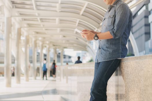 Man is using mobile phone at the walkway.