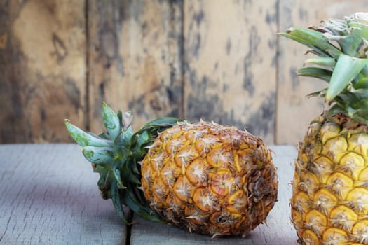 Yellow pineapple on wooden of background.