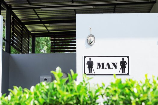 Public bathroom sign for men and women in park.
