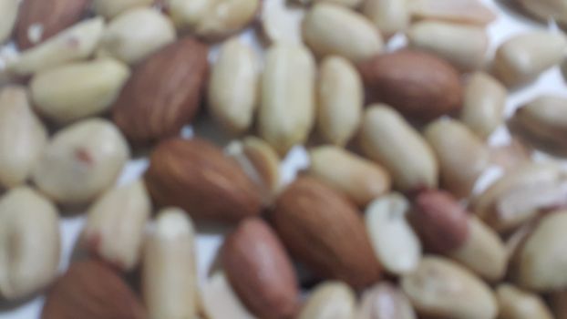 Closeup view of mixed dried and roasted  peanuts and almonds. A fruit for background text