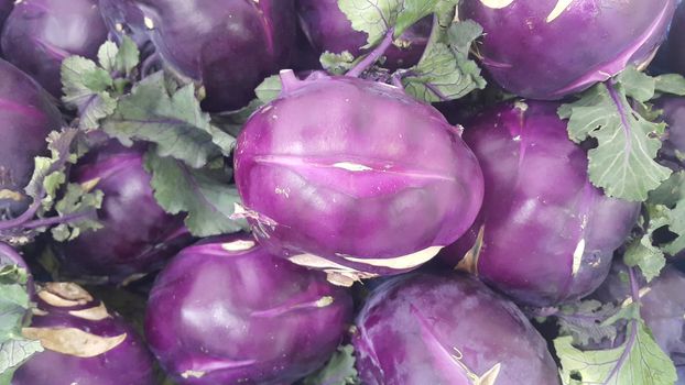 Fruits background: Purple fresh kohlrabi turnip in supermarket for sale.