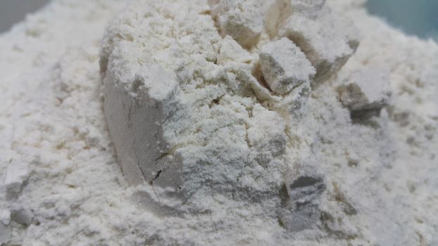 Closeup view of wheat flour heap placed in market for sale. White flour background
