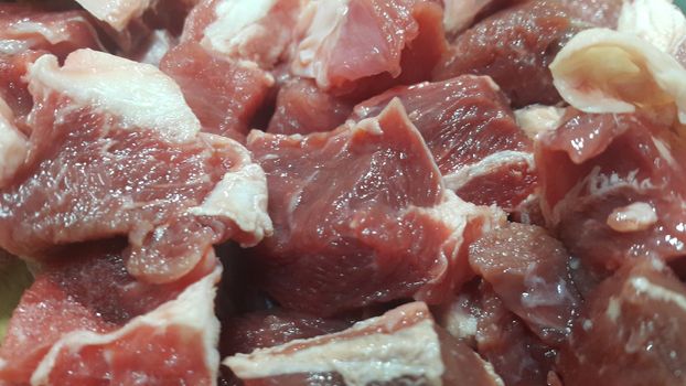 Close up view of fresh finely chopped meat cubes. Red meat small steaks with whitish meat fat.