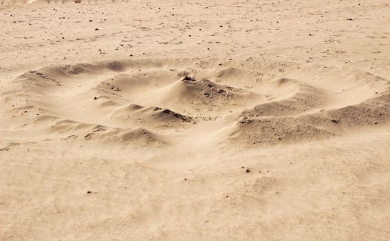 Sand texture and spiral shaped dune on the beach in the morning
