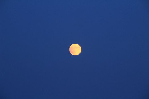 Arenales del Sol Beach in Alicante, Spain, at dusk with a full moon