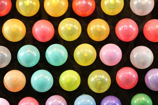 Black panel with colored balloons in a row texture in a fair