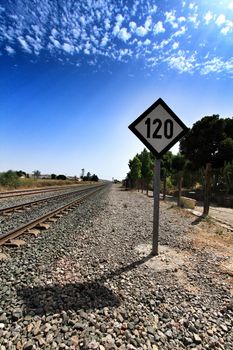 Speed sign limited to 120 km per hour next to train tracks in Spain