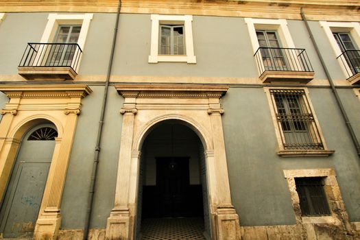 Old facade of a majestic building in Santa Cruz neighborhood in Alicante, Spain